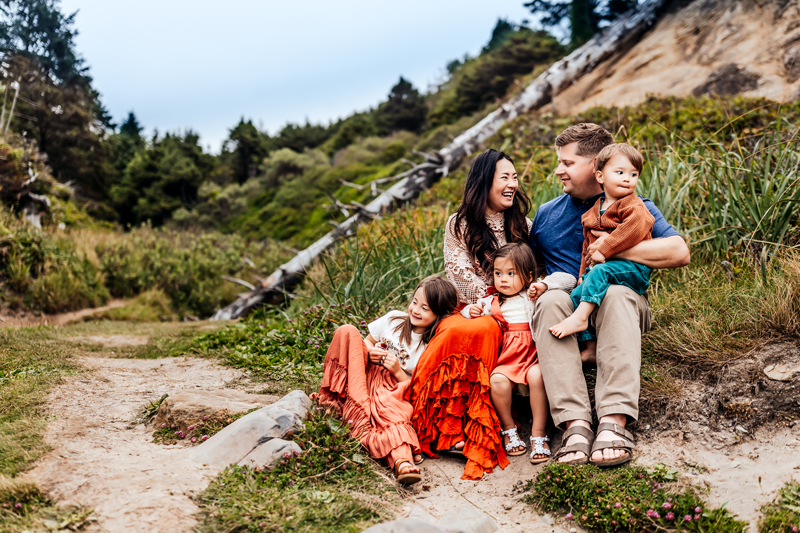 family photography, family cuddled together sitting on a hill